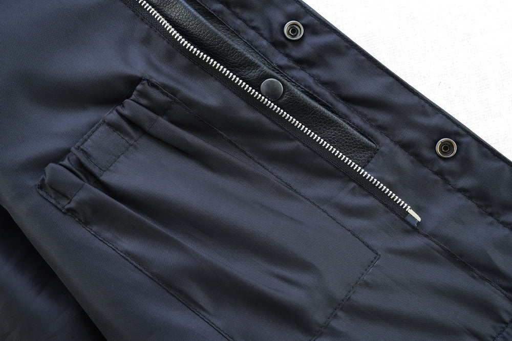 Close-up of a dark-colored Daniel Smart Concealed Snap Closure, Without Collar & Hidden Zipper showing a zippered pocket with a button snap closure and detailed stitching.