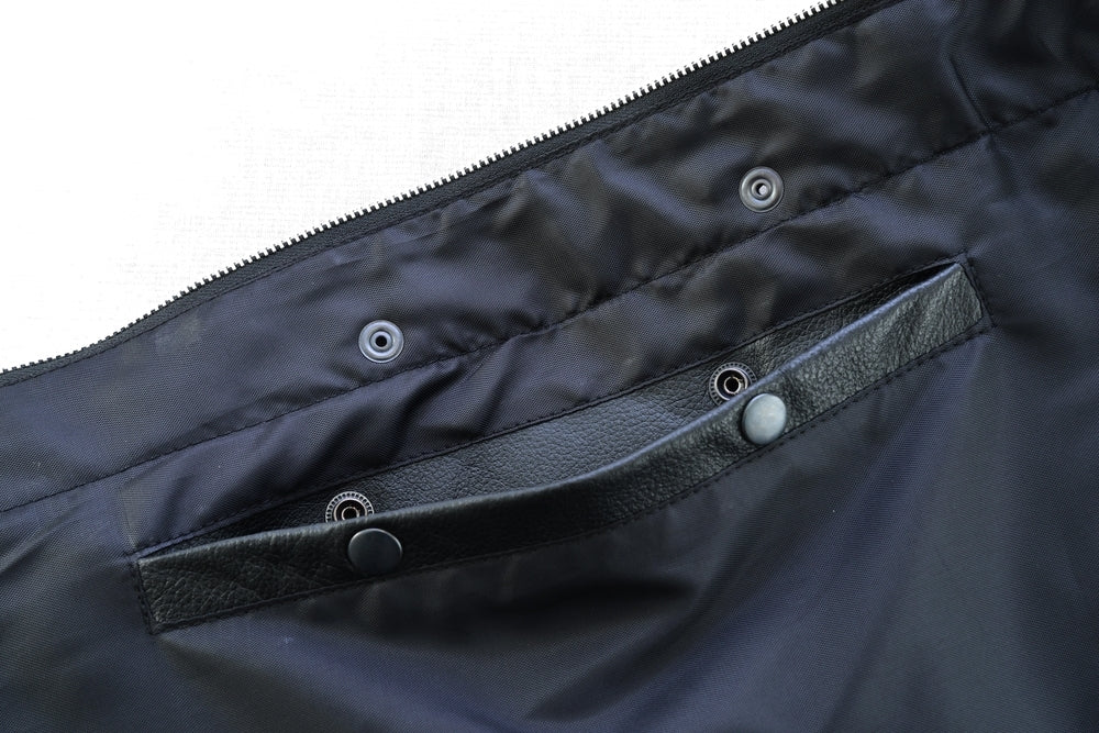 Close-up of a black fabric bag's interior showcasing a zippered section and a leather strap with snap button closures, perfect for organizing your Daniel Smart Concealed Snap Closure, Without Collar & Hidden Zipper.