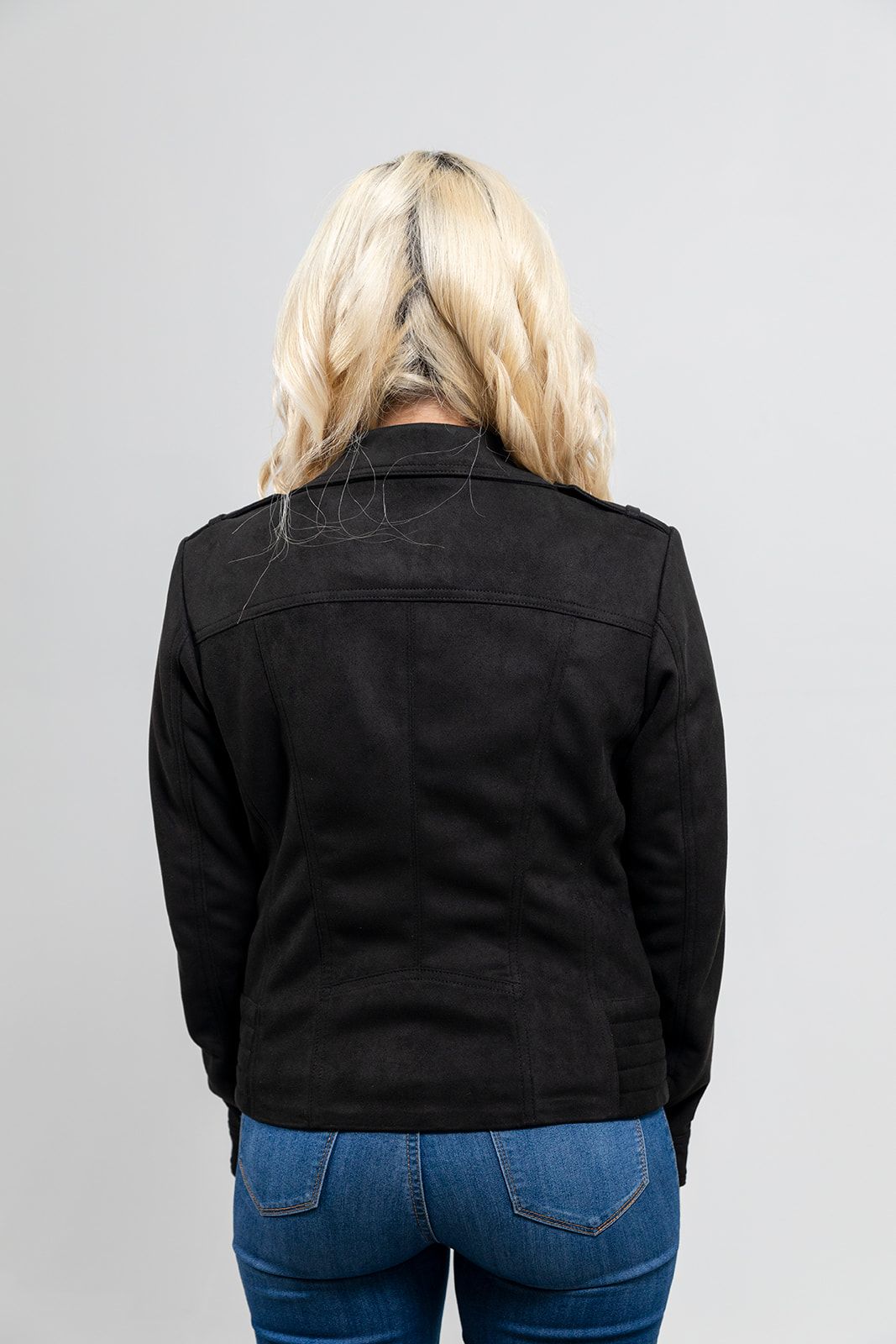 The back view of a woman wearing jeans and the First Manufacturing Molly - Women's Leather Jacket with horizontal zipper pockets.
