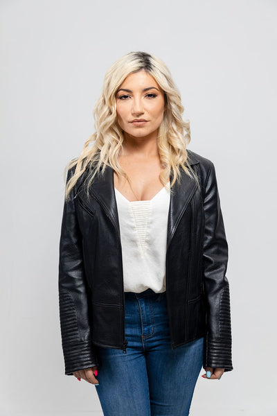 A woman wearing a First Manufacturing Lauren - Women's Vegan Leather Jacket, Black with asymmetrical zipper and jeans.