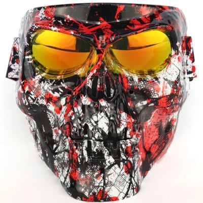 A decorative Skull Face Mask with Detachable Goggles with a splattered red and black paint design and detachable goggles with yellow-tinted lenses.