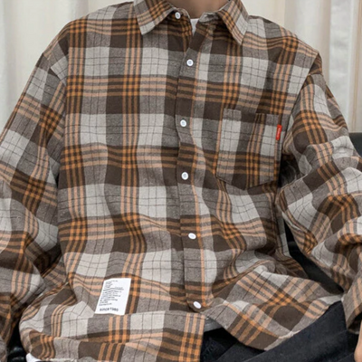 Person wearing an extra thick and cozy Men's Classic Plaid Flannel Shirt, Yellow with a pocket on the left side and a white label near the bottom hem.